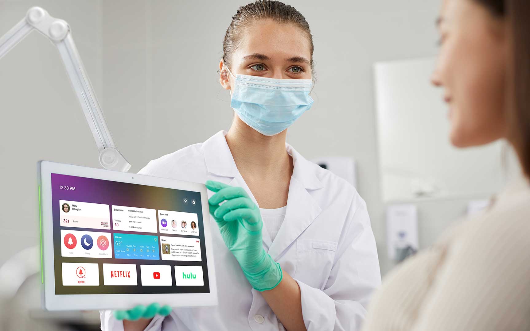 Nurse showing QBOX ConnecTab with a Launcher on the screen to the patient