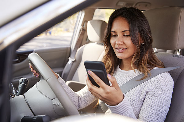 Parent in the car looking at Quicklert Connect App